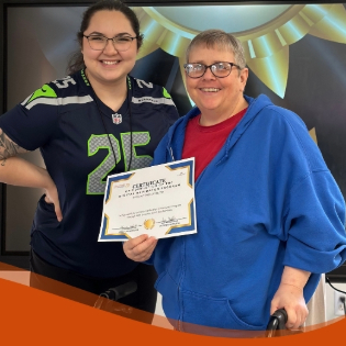 An image of a participant and instructor holding their certificate.