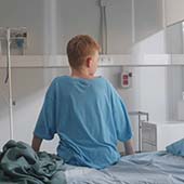 boy in hospital gown facing away from camera
