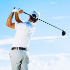 a man swinging a golf club on a sunny day