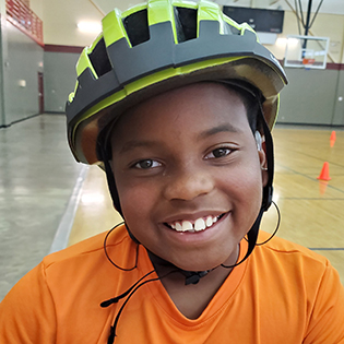 photo of smiling boy wearing a bike helmet