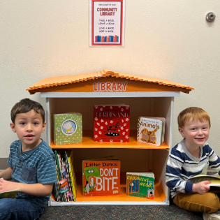 Two young readers enjoying the community library.