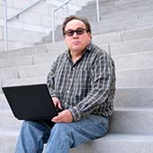 man sitting on steps using a laptop
