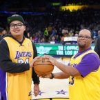 Adult Day Services participants smiling as the camera wearing Lakers jerseys as they hold the game ball.