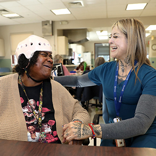 Activity assistant smiling at senior with wearing a helmet