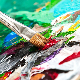 Close-up of paintbrush applying dabs of paint to canvas