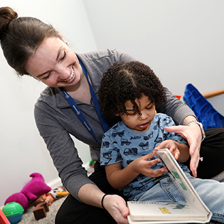 A therapist reading to a child in a Speech-language pathology session