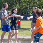 a group of children and teens play on a splash pad outside