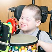 young boy in supportive wheelchair, smiling