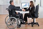 man in wheelchair shaking hands with woman